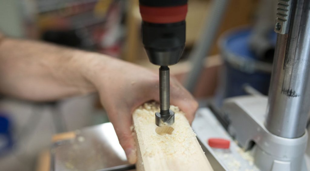 For the eyelets, use a 20 mm forest drill to drill a hole about 15 mm deep. If the four holes are set, switch to an 8 mm wood drill and drill in the middle through the beam.