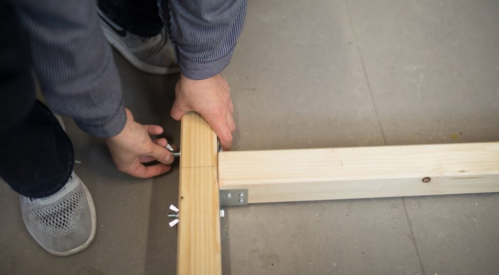 Screw longitudinal and transverse beams with the bolt and with washers on both sides and a wing nut on the outer side of the beams.